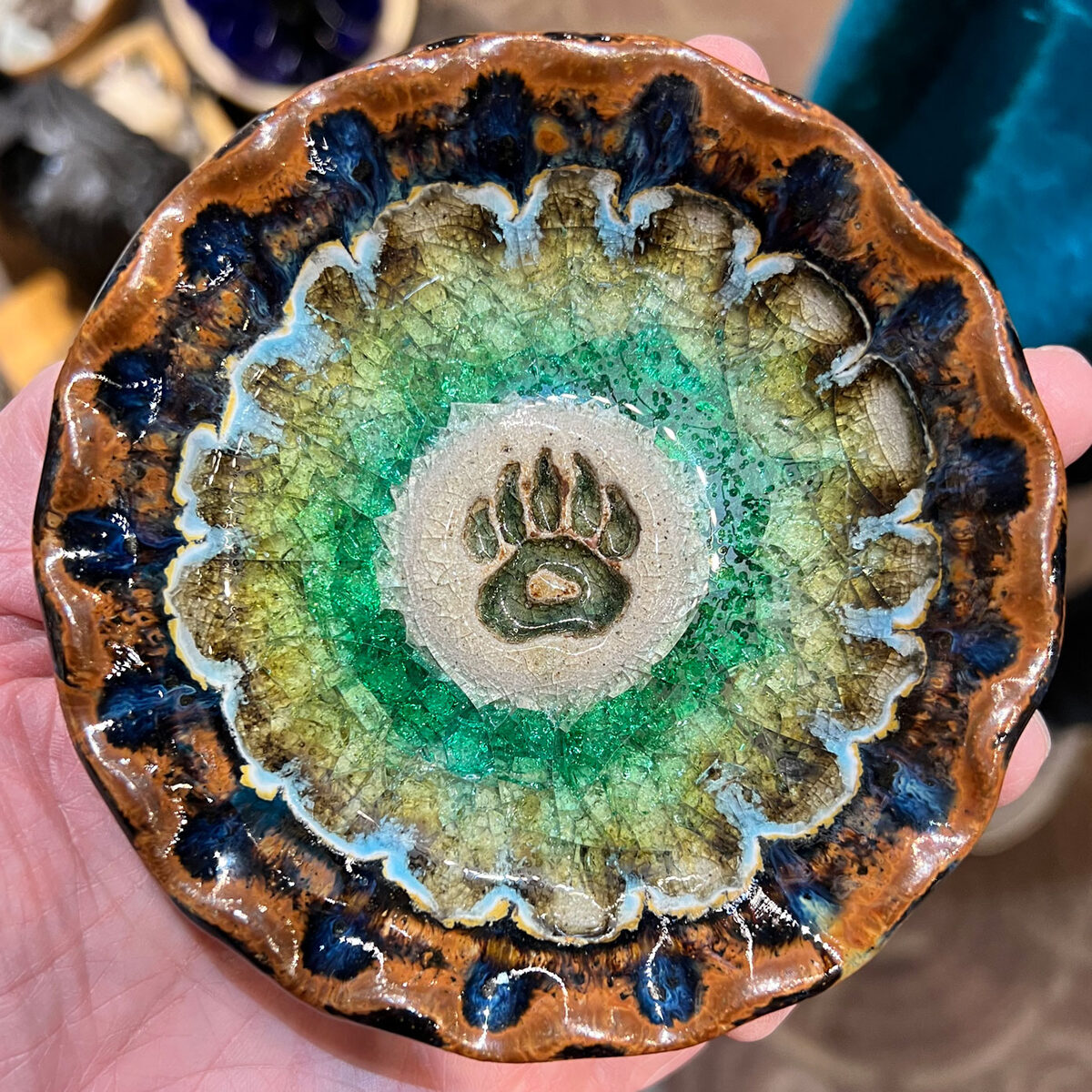 A small pottery bowl with melted glass centre