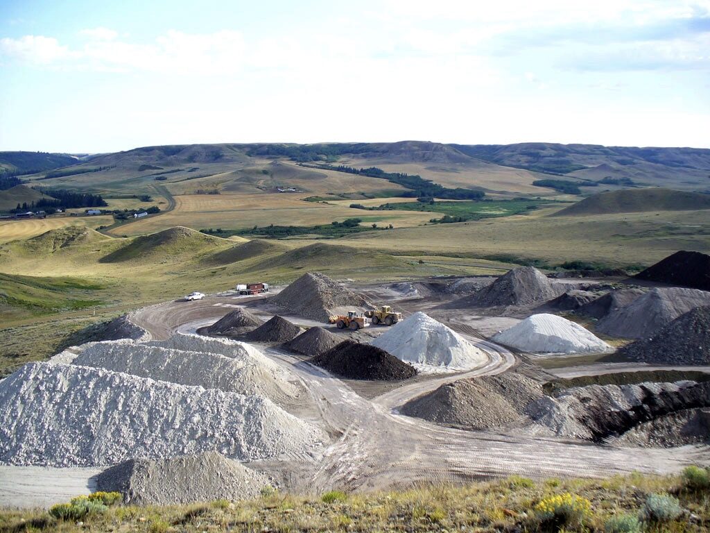 Plainsman Clays is removing layers from the top of a hill Stockpiles of clay and wheel loaders on the flattened hill