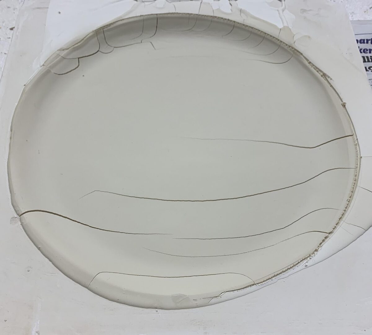 A leather hard plate cracked in the plastic mold