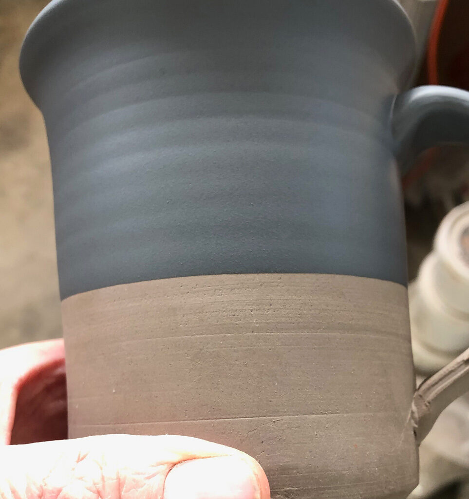 A black engobed leather hard mug