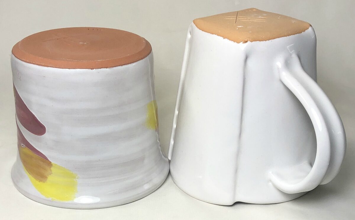 Two white majolica mugs