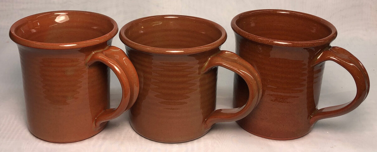 Three clear-glaze terra cotta mugs with rich red color