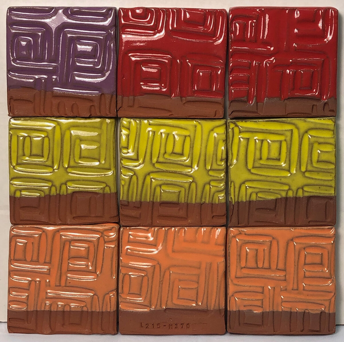 Common mason stains in the G2806N v1 base Four tiles of a red-burning clay covered with purple, yellow, orange, black glazes