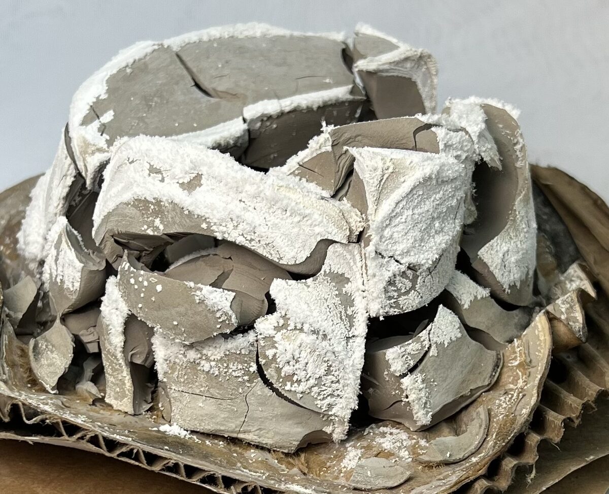 A dry lump of bentonite with solubles as a powder