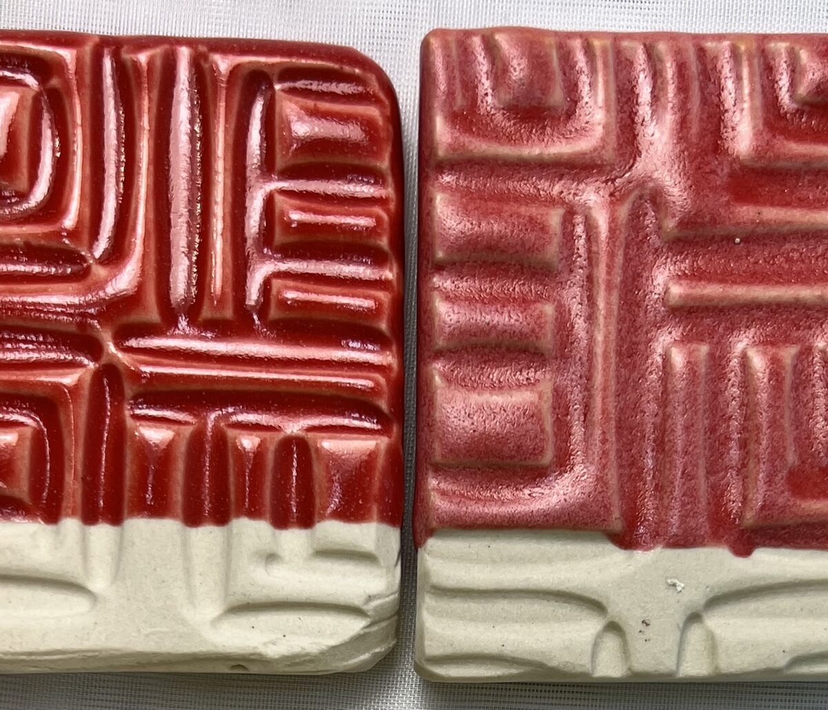Two bight red glaze test tiles