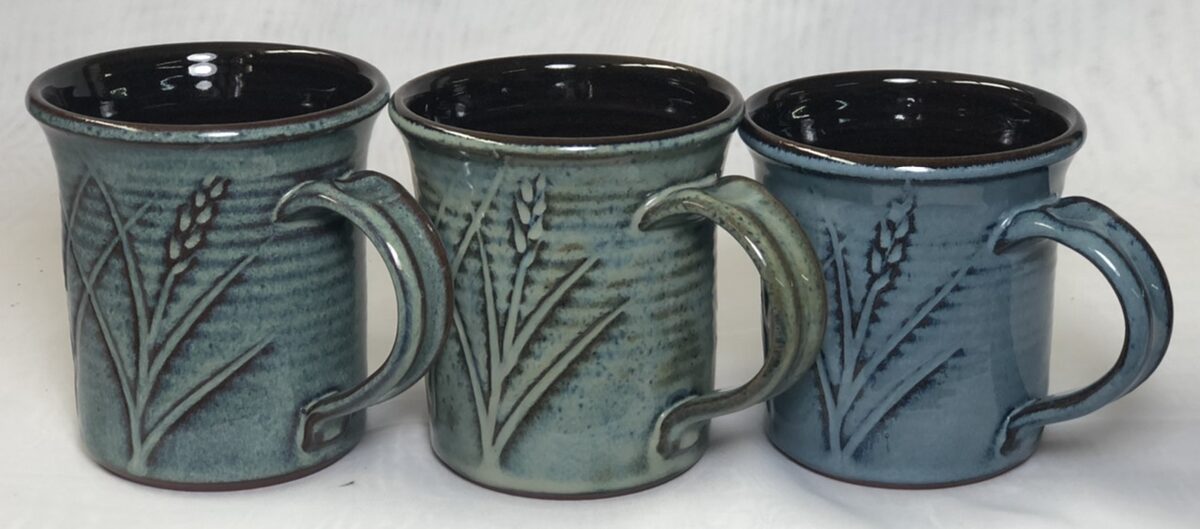 Three mugs with floating blue glazes
