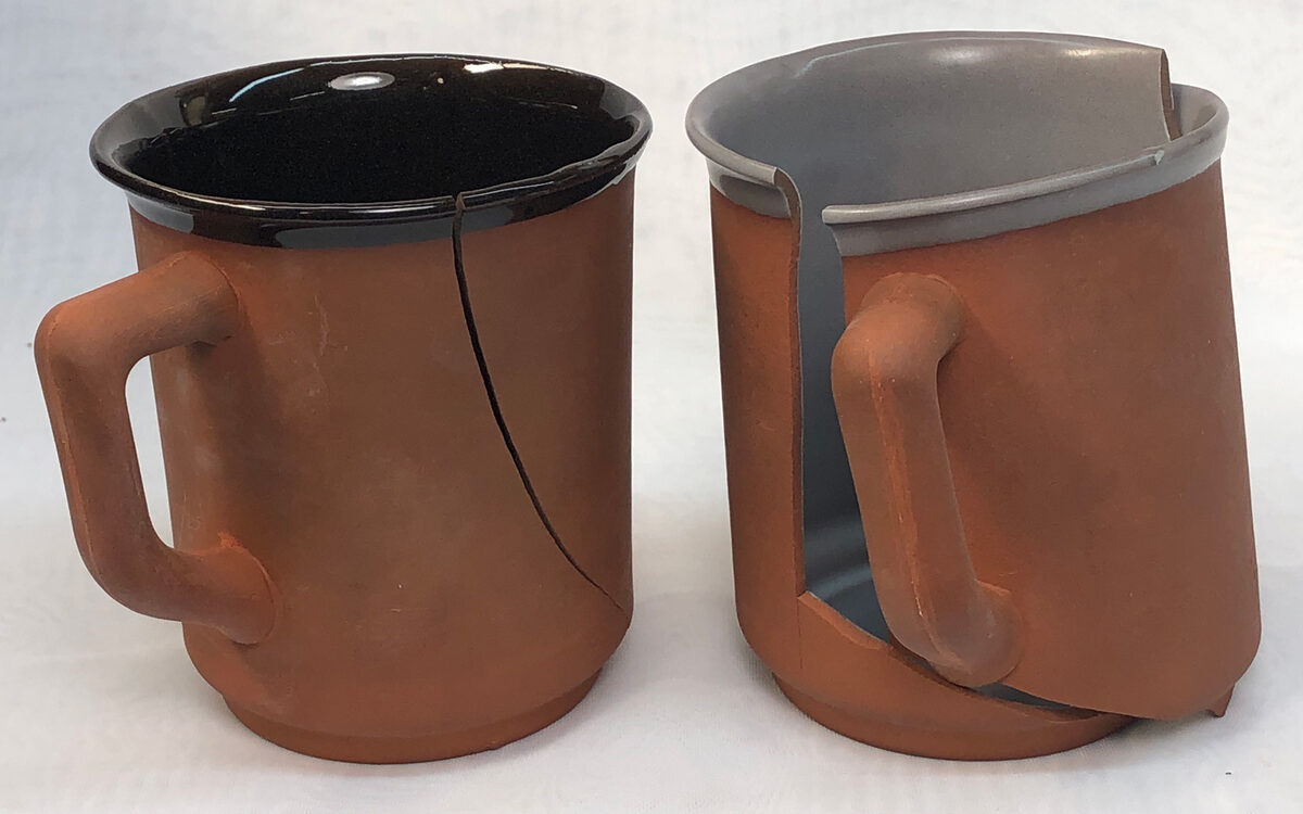 Two coffee mugs, one cracked, the other shattered